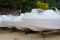 Power boat parking covered white protective plastic film new modern boats in cover casing shrink wrap on sailboat stored for