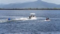 A power boat pulling children on tubes at a local dam