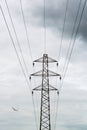 Power cable tower and a small plane on overcast day Royalty Free Stock Photo