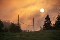 Power cables over a foggy field at sunrise Royalty Free Stock Photo