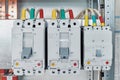 Power circuit breakers are arranged in a row in an electric Cabinet.