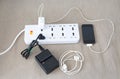 Power cord with several adapters and chargers for various electronic devices in a paperless office