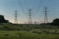 Power Electrical Lines From Hydro Electric Plant by Fields at Sunrise Sunset Royalty Free Stock Photo