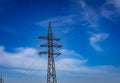 Power grid pylon against blue cloudy sky. Royalty Free Stock Photo