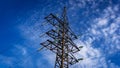 Power grid pylon against blue cloudy sky. Royalty Free Stock Photo