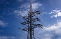 Power grid pylon against blue cloudy sky. Royalty Free Stock Photo