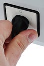 Power is on - hand of adult man holding main electric power switch in on position, white background