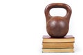 Power of knowledge. Weight on stack of books. Old iron weight. Royalty Free Stock Photo