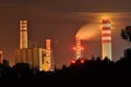 Power lights illuminated at night. Chimneys launching smoke. Cranes, extending the electron. Heat generation. Royalty Free Stock Photo