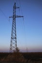 Power line against the backdrop of a landscape with a sunset, electric poles, evening Royalty Free Stock Photo