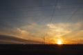 Power line against the backdrop of a landscape with a sunset, electric poles, evening Royalty Free Stock Photo