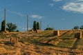 Power line the bales of straw on a mown wheat field Royalty Free Stock Photo