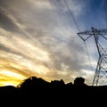 Power line on hill silhouetted against cloudy sky Royalty Free Stock Photo