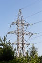 Power line support is located in the forest part of the outdoor. Transmission of electricity, the high tower Royalty Free Stock Photo