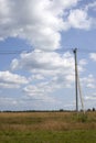 Power line under blue sky with clouds of white