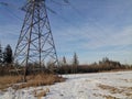 Power line in winter, passing through a snow-covered field Royalty Free Stock Photo