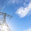 Power lines against blue sky on a sunny day Royalty Free Stock Photo