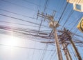 Power lines in the city. Transformers and phone lines against bright blue sky. Royalty Free Stock Photo