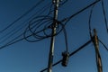 Power lines, electric poles with black straight and twisted wires and small transformer bank. Backdrop blue gradient Royalty Free Stock Photo