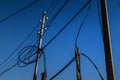 Power lines, electric poles with black wires on bright blue sky Royalty Free Stock Photo