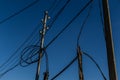 Power lines, electric poles with black wires on bright blue sky gradient Royalty Free Stock Photo