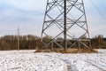 Power lines in the field. Industrial tower in the snow. Power line in the field in the winter