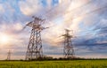 Power lines and high-voltage lines against the backdrop of blooming oilseed rape on a summer day Royalty Free Stock Photo