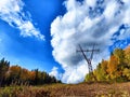 Power lines on a hill, hill or in the mountains against a blue sky with white clouds. Electric lines, towers, wires in Royalty Free Stock Photo
