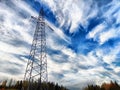 Power lines on a hill, hill or in the mountains against a blue sky with white clouds. Electric lines, towers, wires in Royalty Free Stock Photo