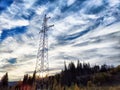 Power lines on a hill, hill or in the mountains against a blue sky with white clouds. Electric lines, towers, wires in Royalty Free Stock Photo
