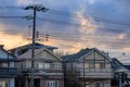 Power Lines Over Suburban Homes With Storm Clouds At Sunrise