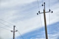Power lines, poles and poles among the blue sky and clouds. Wires through which electricity passes Royalty Free Stock Photo