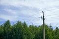 Power lines, poles and poles among the blue sky and clouds. Wires through which electricity passes Royalty Free Stock Photo