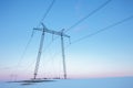 Power lines in snow field at pastel sunset Royalty Free Stock Photo