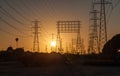 Power lines with towers in silhouette at sunset Royalty Free Stock Photo