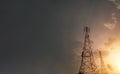 Power plant silhouette At sunset, a high-voltage tower stands against the sky. Electrical transmission wires from the bottom Royalty Free Stock Photo