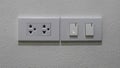 Power plug, separate light switch, white cement wall Royalty Free Stock Photo