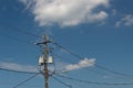 Power pole and lines with transformers and street light, blue sky with clouds Royalty Free Stock Photo