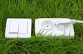 Power receptacle and light switch on a green grass Royalty Free Stock Photo