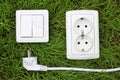 Power receptacle and light switch on a green grass Royalty Free Stock Photo