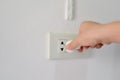 Power saving concept, Hand plug and unplug the electric socket on white wall. Royalty Free Stock Photo