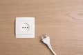 Power socket with plug on wooden table, flat lay. Space for text Royalty Free Stock Photo