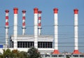 Power station building with many high red and white industrial pipes over clear cloudless blue sky Royalty Free Stock Photo