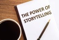 THE POWER OF STORYTELLING - text on notepad on wooden desk