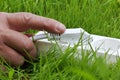 Power strip lying on the grass and hand Royalty Free Stock Photo