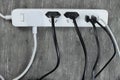Power strip with multiple electrical cords plugged in on gray background
