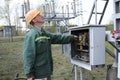 At the power substation. Worker checking connections on the electric board turning start tumbler. Pump station