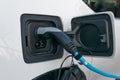 The power supply charger plugged into an electric car being charged close up