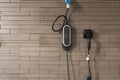 Power supply for hybrid electric car charging battery on wall brick background. Eco-car concept Royalty Free Stock Photo