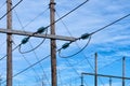 Power supply line with three wires mounted on old wooden pillar, blue sky with soft white clouds at background, close up photo Royalty Free Stock Photo